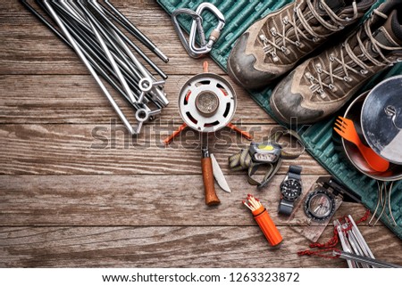 overhead view of camping gear on a wooden surface Royalty-Free Stock Photo #1263323872