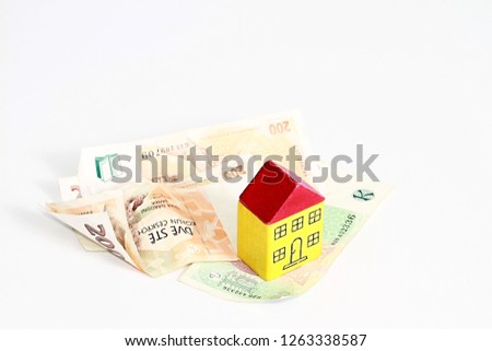 property purchase representing with miniature toy block houses with money on table with white background no people stock photo