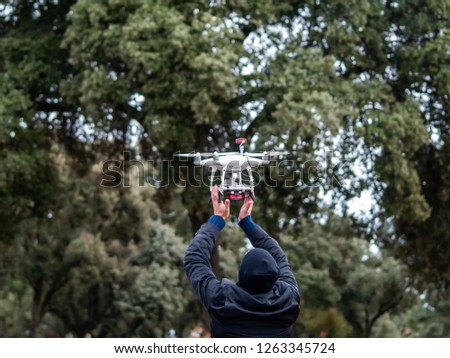 A drone landing in the hands of a man in the forest Royalty-Free Stock Photo #1263345724