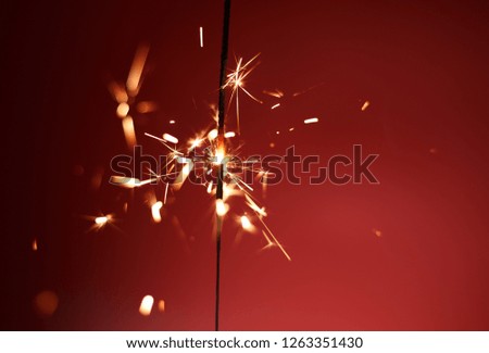  New Year's sparkler on a red background. Celebration
