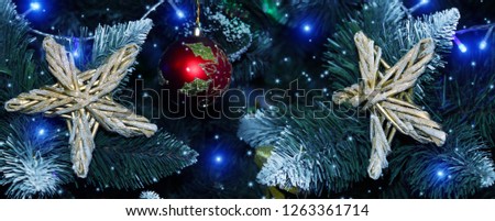 Red ball and golden star on the Christmas tree. Christmas background with bokeh, lights and snowflakes