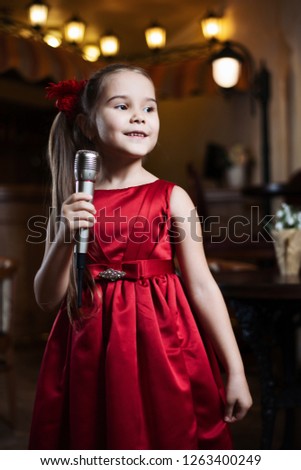The girl with the microphone. A small child sings karaoke