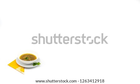 A 4k picture of a delicious soup dish with pasta and vegetables, decorated with parsley, over a orange napkin and in the left-down corner of a large and clean white background