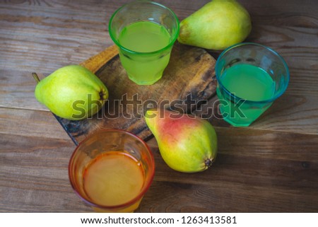soda pop in a glass cup next to a pear