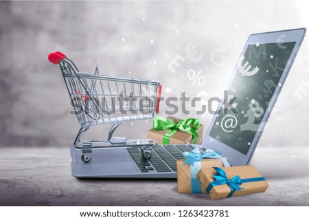 Concept online shopping buying presents. Red credit card, keyboard and christmas presents on grey table flat lay, copy space. Business christmas holidays concept, holiday gift online shopping concept.