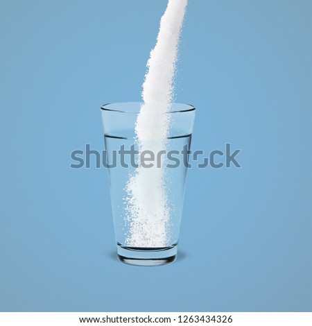 Pouring powder on water glass on  background