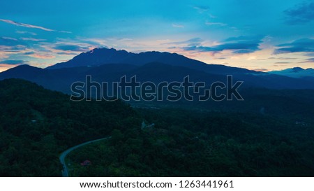 An aerial view of Mount Kinabalu Kundasang at far background during in the sunrise - morning at Sabah, Malaysia. Photo has grain, blurry, noise and soft focus due to low light condition.