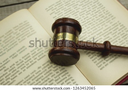 Judge gavel on open book, close up.