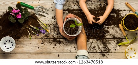 Love nature concept. The family works together. Family business. Ecology and environment. A child with parents plant flowers in pots. Together. Heart of soil. Plant flower shop. Sweet home
