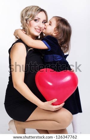 happy mother and her daughter with big red balloon