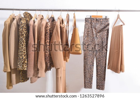 female brown leopard pattern clothes, coat, jacket, brown sweater ,handbag, scarf on hanger


