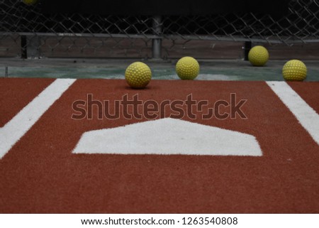 Batting cage home plate and softballs Royalty-Free Stock Photo #1263540808