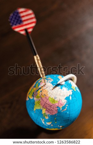 USA concept targeting Russia. Darts arrow pricked on Russia on globe. American flag on arrow pointing Russia as target on the globe. The United States focused on Russia on the map.