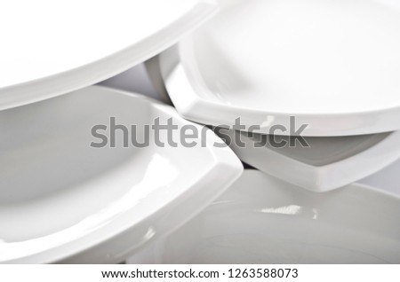 Abstraction from the plates.. Beautiful table setting with restaurant utensils in various combinations in an interesting, creative design on a white and light background and in the form.
