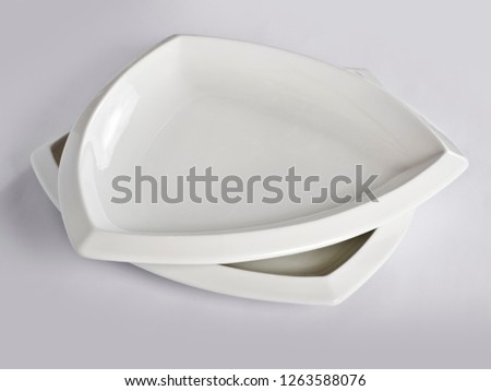 Abstraction from the plates.. Beautiful table setting with restaurant utensils in various combinations in an interesting, creative design on a white and light background and in the form.