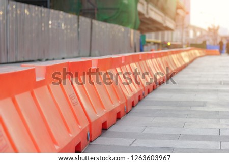 Orange plastic barriers lined up on the road.