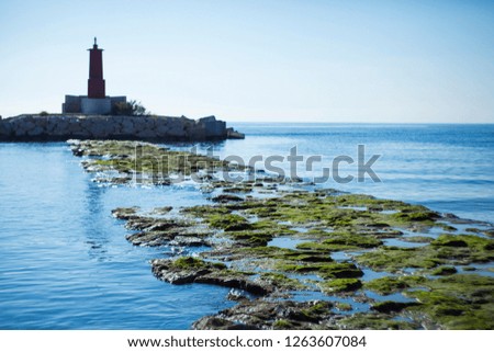 Lighthouse on the sea. Sea view. Lighthouse on a sunny day. Beautiful view of the sea. The road to the lighthouse.