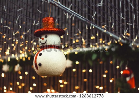 Snow man, Christmas decoration with blurry lights background in low light tone with copy space. Happy New year celebration in holiday.
