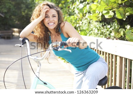 Happy Female Taking A Break On Boardwalk With Bicycle