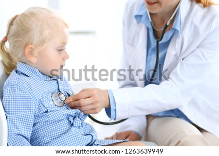 Doctor and a little blonde girl. Usual health exam. Medicine and healthcare concept
