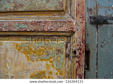 Old grungy wooden door. Peeling paint. Closeup. Vintage background.