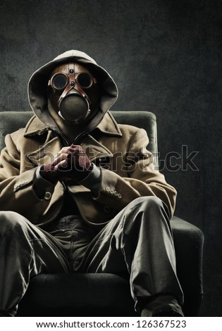 Man in gas mask sitting in a chair Royalty-Free Stock Photo #126367523