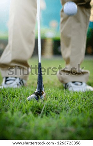 Golfers are holding a golf club and golf ball moving