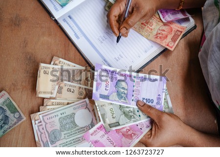 indian Currency (Rupee) 2000,500,100,50,10,1Rupee. 
 Close up of female accountant or banker making calculations