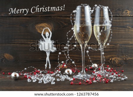 Merry Christmas romantic composition postcard. Glasses of champagne and festive silver decoration ornament on wooden vintage background