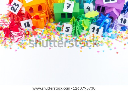Advent calendar for baby rainbow color. House and Christmas tree paper craft. Christmas holiday decor. White background. Numbers on the label.