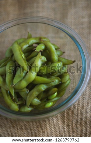 close up portrait of Japanese food edamame nibbles, boiled green soybeans 