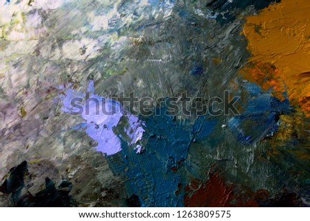 multi-colored strokes of oil paint on the artist's palette. background