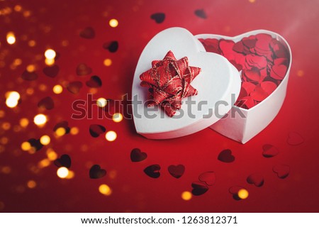 Heart shaped gift box with heart confetti. Passion, love and feelings St Valentine's celebration concept with copy space
