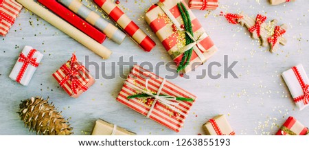 Christmas background with confetti, christmas balls, and red gift boxes on the white wooden board