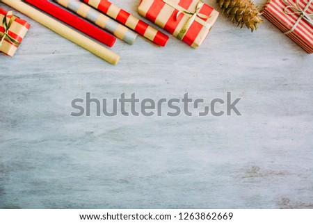Christmas background with confetti, christmas balls, and red gift boxes on the white wooden board