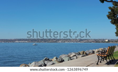 Tranquil views with few benches,  towards North San Diego Bay by Sunroad Resort Marina, known for recreational activities such as sailing, museum ships and sightseeing boats San Diego, California, USA