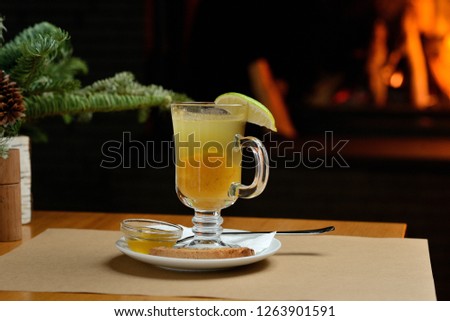 berry tea with lemon in a transparent glass on the background of the fireplace, Christmas tea