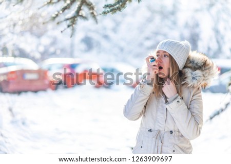 Portrait of a woman using an asthma inhaler in a cold winter. Woman with Inhaler Suffering Asthma Attack in Winter Asthmatic patient managing condition with medication in cold season 