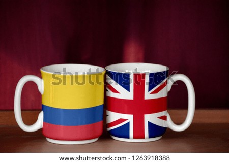 United Kingdom and Colombia flag on two cups with blurry background