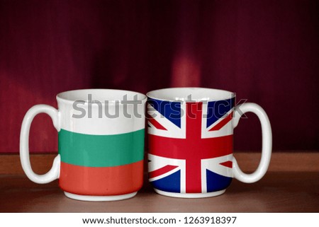 United Kingdom and Bulgaria flag on two cups with blurry background