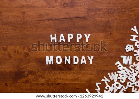 White wooden alphabet "Happy Monday" text on wooden background. Flat lay concept.