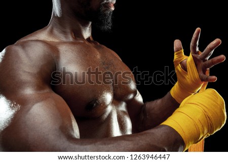 Afro American boxer is wrapping hands with yellow bandage