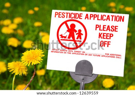 Pesticide Application sign with dandelions in the background