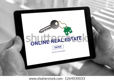 Male hands holding a tablet with online real estate concept