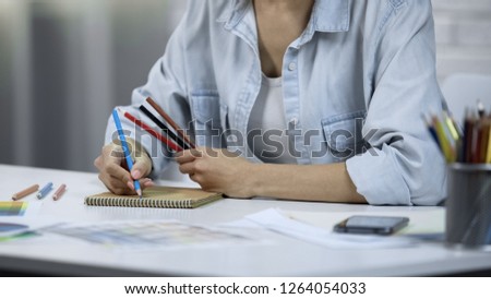 Young woman designing interior, freelancer doing work, coloring with pencils