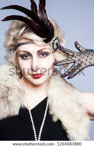Retro portrait of a girl in a hat with feathers and lace gloves