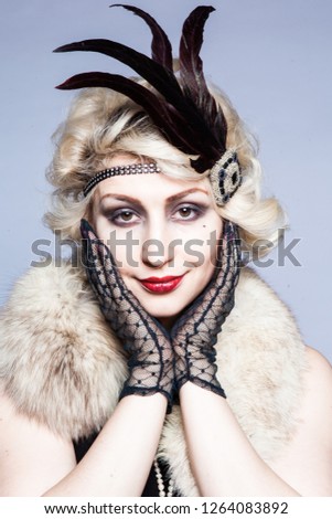 Retro portrait of a girl in a hat with feathers and lace gloves
