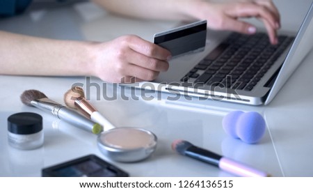 Make-up artist ordering new cosmetics online, typing data of her credit card