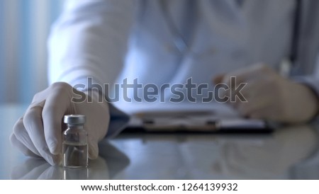 Immunologist holding bottle with medication and giving vaccine to patient, care Royalty-Free Stock Photo #1264139932