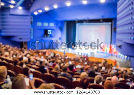 Defocused image. People in the auditorium. International conference. Flags of different countries on stage. Royalty-Free Stock Photo #1264143703